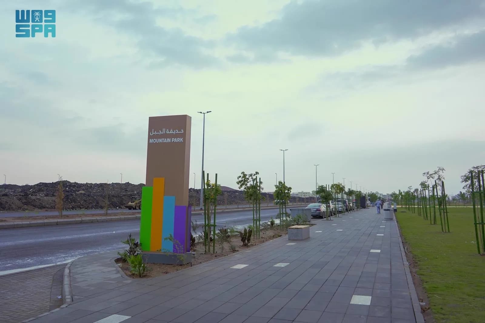 لوحة مدخل حديقة الجبل والممشى المرصوف بجوار الطريق