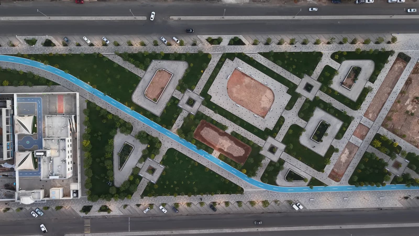 منظر علوي للأحواض الهندسية ومسار الدراجات الأزرق بين الشوارع