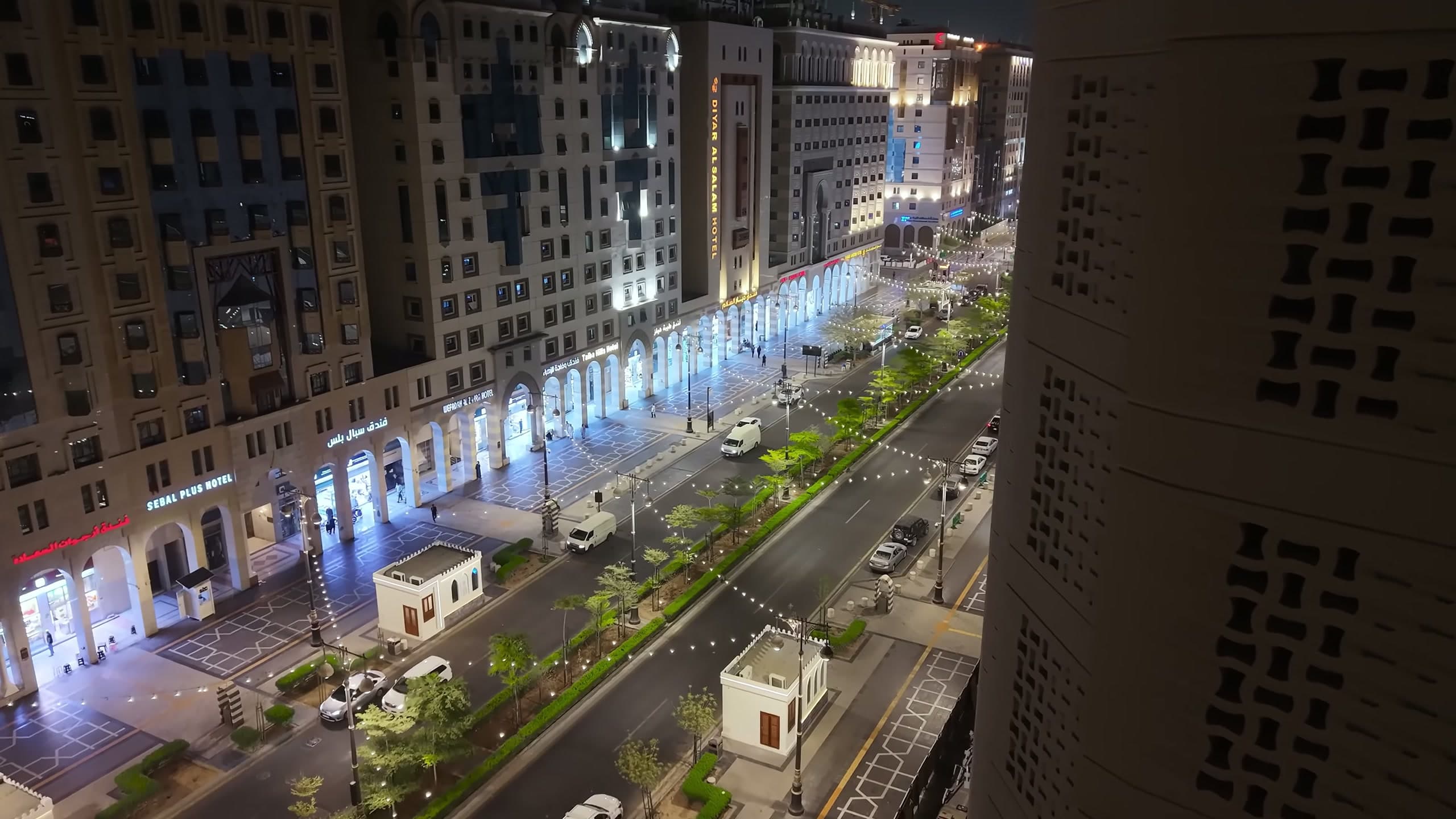 Oblique night view of the Central Area corridor with lighting columns and illuminated arcades along the frontages