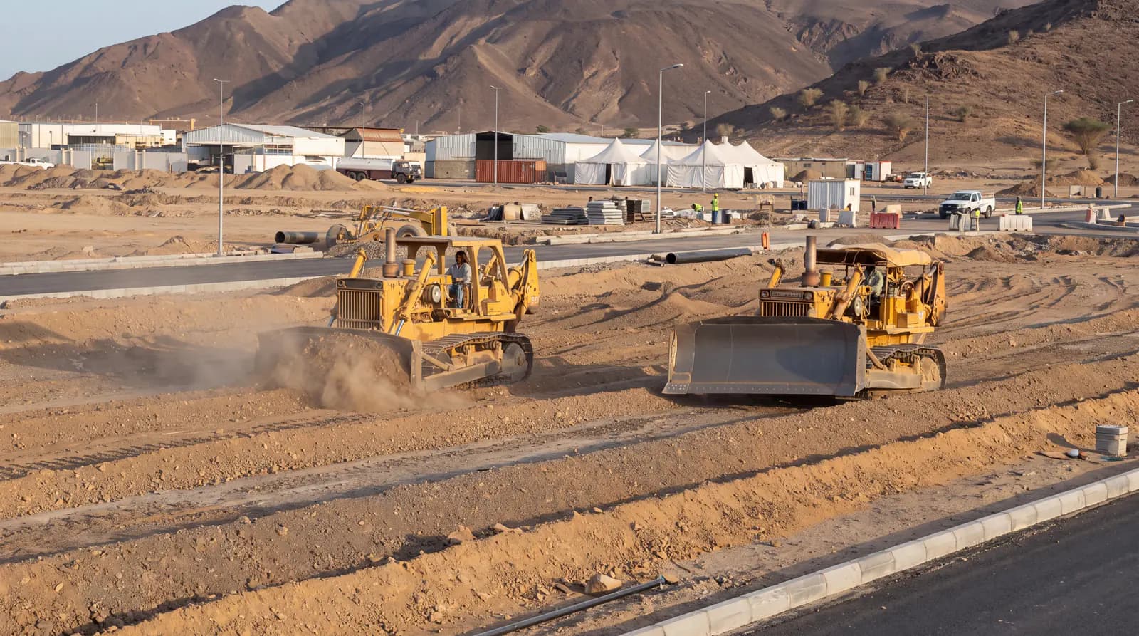 Grading and excavation equipment carrying out land-preparation works in a private development