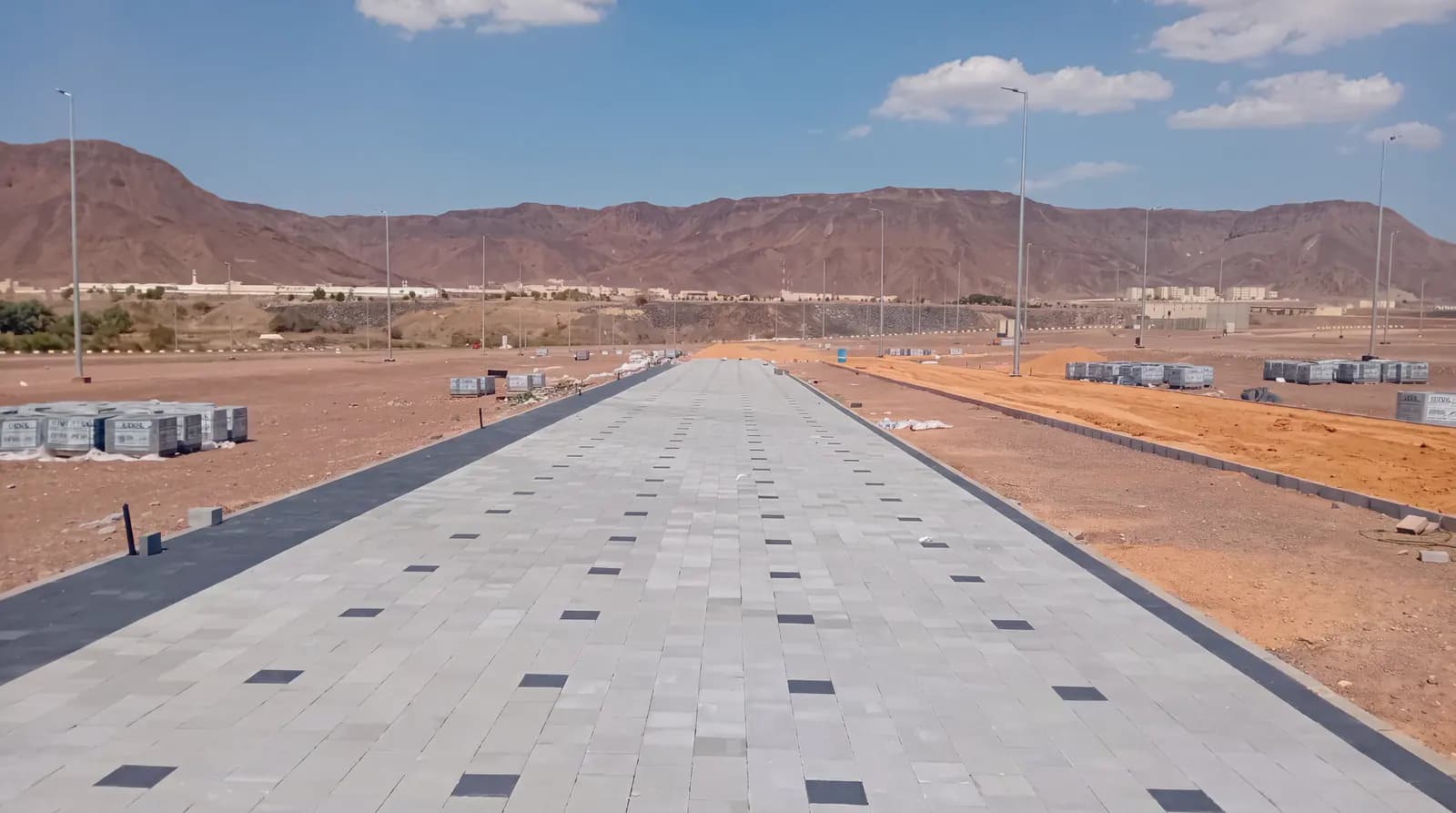Long paved walkway after completion of hardscape works in a private development